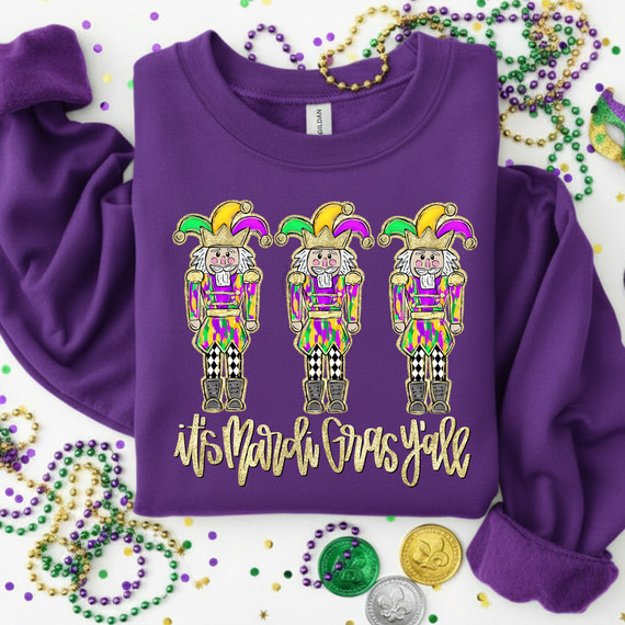 It's Mardi Gras Y'all Nutcrackers DTF Heat Transfer, purple sweatshirt with colorful nutcracker design and Mardi Gras themed text.