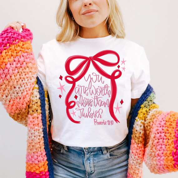 You Are Worth More Than Rubies Bow DTF Heat Transfer, a design on a white t-shirt featuring a large pink and red bow with pink handwritten-style text.