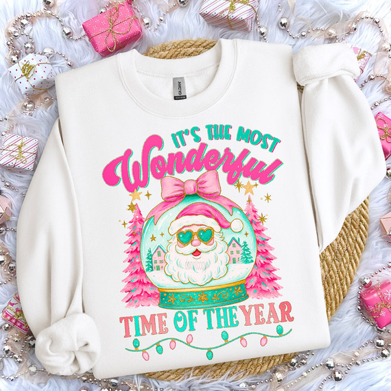 Retro Most Wonderful Time Of The Year DTF Heat Transfer, Christmas-themed graphic with a snow globe featuring Santa Claus with sunglasses, pink bow, and surrounding Christmas trees and ornaments