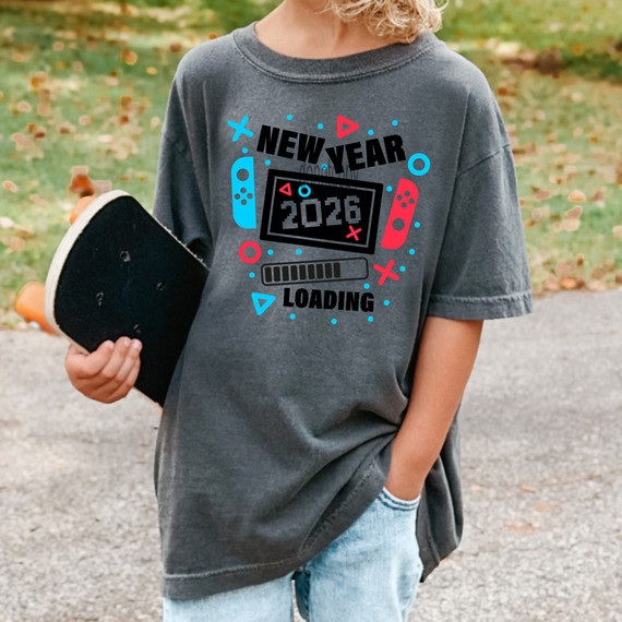 New Year 2026 Loading DTF Heat Transfer, colorful graphic design of a smartphone with a loading bar and festive elements on a t-shirt.