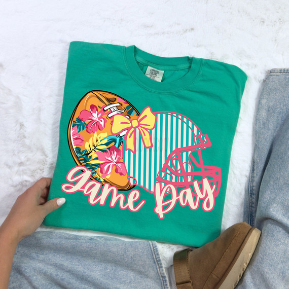 Preppy Tropical Football Game Day DTF Heat Transfer, colorful tropical football design with a floral pattern and a bow, suitable for team or game day apparel.