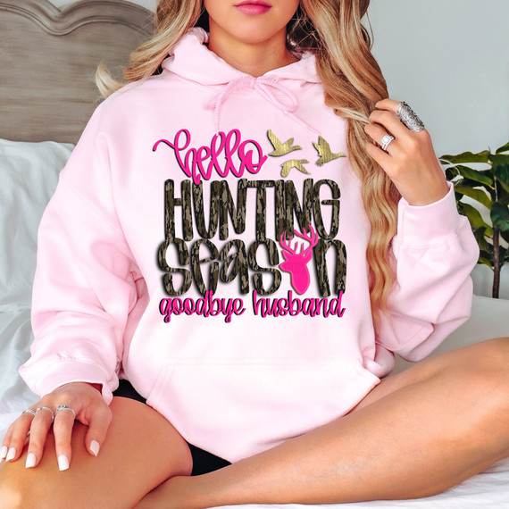 Pink Hello Hunting Season, Goodbye Husband Camo DTF Heat Transfer: A woman wearing a pink hoodie with hunting-themed design, featuring a deer head, birds, and text, used as a heat transfer for clothing.