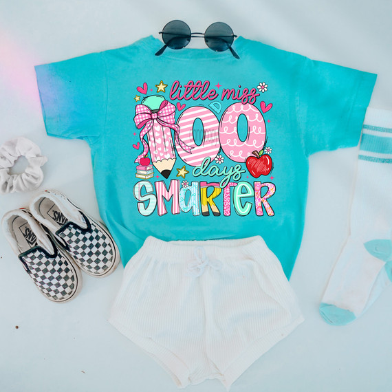 Little Miss 100 Days Smarter DTF Heat Transfer, colorful and fun graphic design on a turquoise t-shirt with pink, yellow, and blue accents, featuring a pencil, apple, and books.