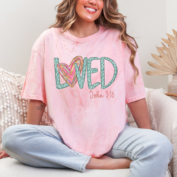 Loved John 3:16 Brushstroke Heart DTF Heat Transfer, woman wearing pink tie-dye t-shirt with colorful heart and "LOVED" text design.
