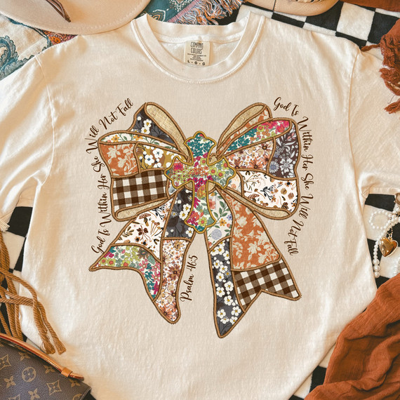 God Is Within Her, She Will Not Fall Faux Embroidery Patchwork Bow DTF Heat Transfer T-Shirt, white sweatshirt featuring a colorful embroidered bow design with floral and checkered fabric patches and scripture quote.