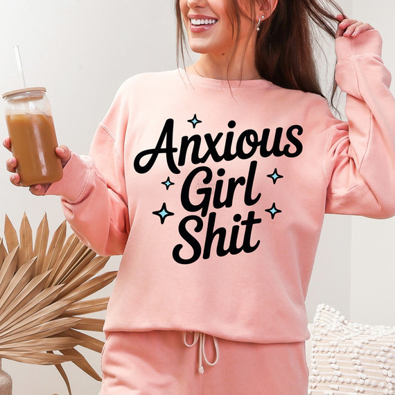 Anxious Girl Shit DTF Heat Transfer, a woman wearing a pink sweatshirt with bold black text and small decorative stars, holding iced coffee and smiling.
