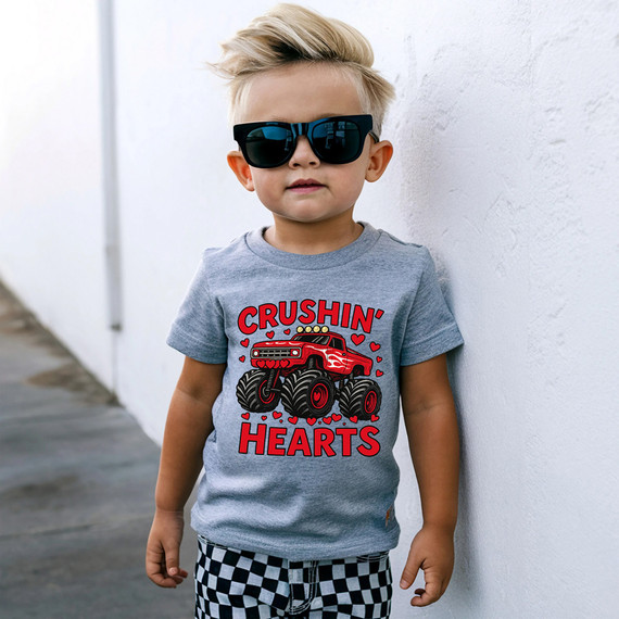 Crushin' Hearts Monster Truck DTF Heat Transfer, graphic of a red monster truck surrounded by hearts on a gray t-shirt worn by a young boy.