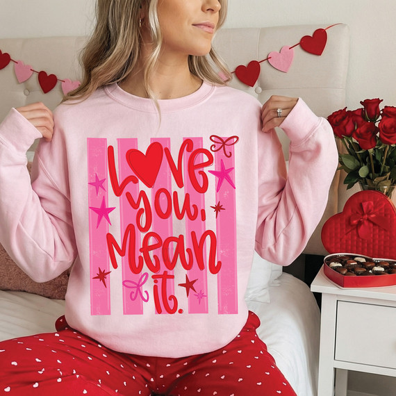 Love You Mean It Retro Stripe DTF Heat Transfer, pink sweatshirt with Valentine's Day themed text and graphics, including hearts and stars.