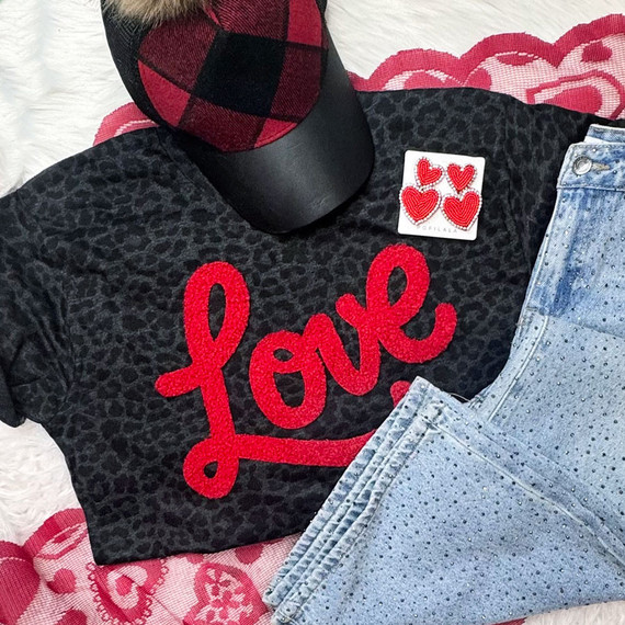 Red Love Fluffy Patch, red embroidered love text patch with heart motifs on a black leopard print t-shirt.