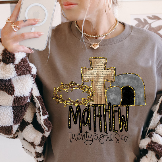 Matthew Twenty Eight Six DTF Heat Transfer, close-up of woman using a smartphone to showcase a religious-themed heat transfer design on her sweatshirt.