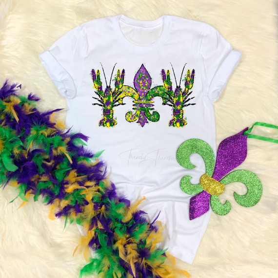 Paint splatter Fleur de lis crawdads Mardi Gras Sublimation Transfer, featuring colorful paint splatter crawdads and fleur de lis design on a white t-shirt with Mardi Gras themed feather accessories.