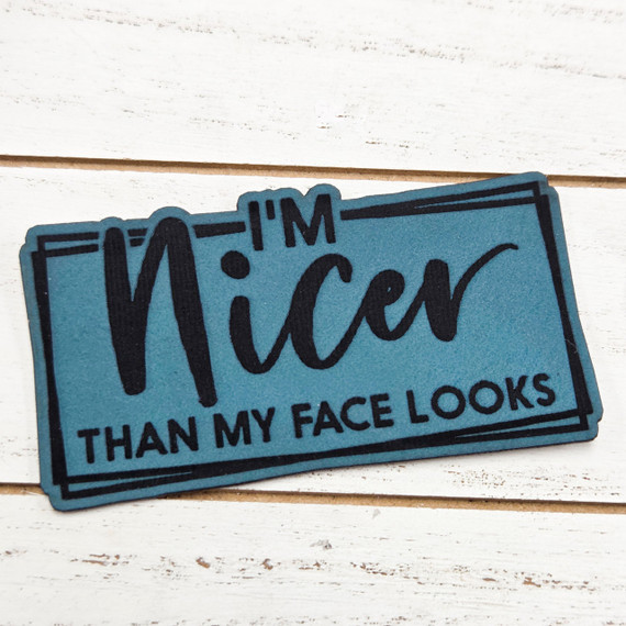 I'm Nicer Than My Face Looks FAUX Leather Patch, humorous blue faux leather patch with black text and border design.