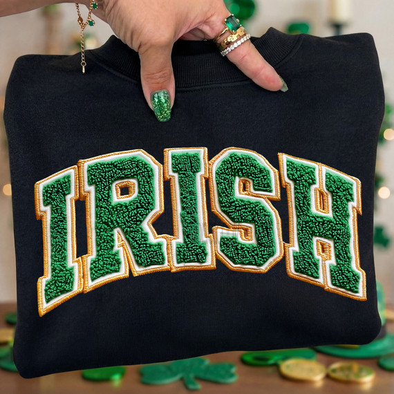 Faux Chenille Irish DTF Heat Transfer, close-up of green and gold embroidered word 'Ireland' on black sweatshirt.