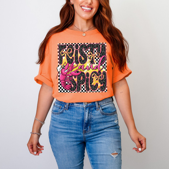 Feisty & Spicy DTF Heat Transfer, colorful design featuring a shrimp, bows, and bold text on a woman's orange t-shirt.