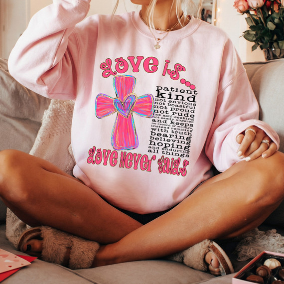 Love Is... DTF Heat Transfer, colorful design featuring a pink and blue cross with a heart in the center, and positive affirmations about love.