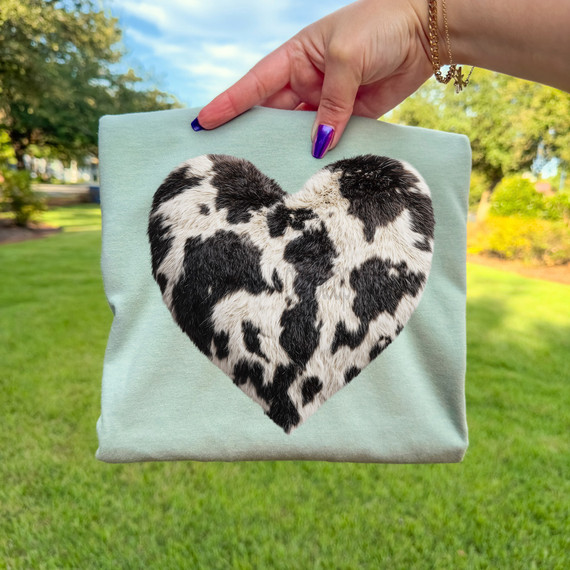 Faux Patch Cowhide Heart DTF Heat Transfer, heart-shaped cowhide patch on a light-colored fabric item.