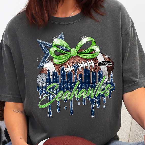 Faux Sequins Seahawks City Skyline DTF Heat Transfer, a glittery design featuring a football with a green bow, city skyline, and the word 'Seahawks' in sparkle text on a black t-shirt.