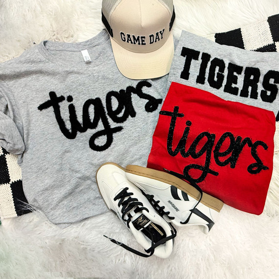 Tigers Fluffy Patch, close-up of a fluffy patch with the word 'tigers' in black on a gray background, applied to various apparel items and accessories.