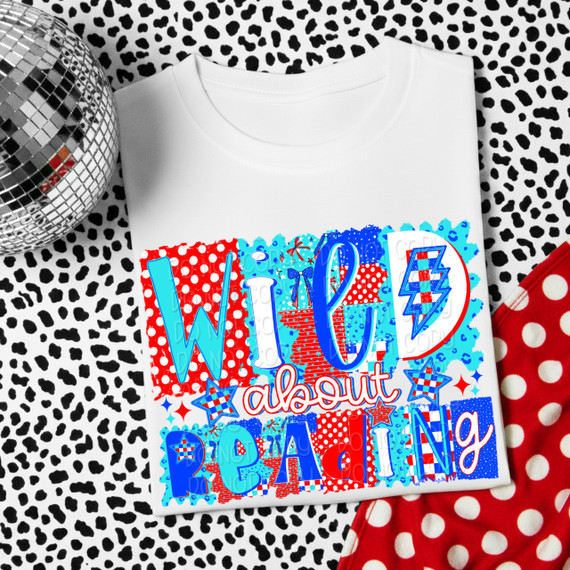 Wild About Reading DTF Heat Transfer, colorful design with text and fun patterns on a white T-shirt, placed on a black and white animal print background with a disco ball and red and white polka dot fabric nearby.