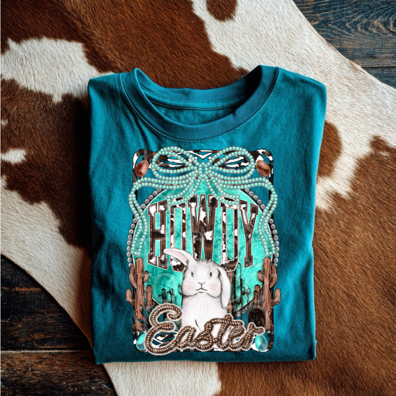 Howdy Easter DTF Heat Transfer, colorful Easter-themed design with a bunny, cacti, and decorative lettering on a turquoise T-shirt.