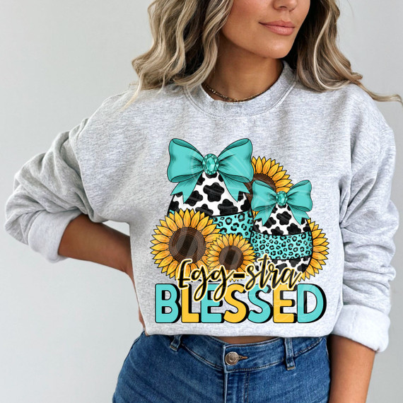 Egg-stra Blessed DTF Heat Transfer, colorful design of decorated Easter eggs with sunflowers and teal bows on a woman's sweatshirt.
