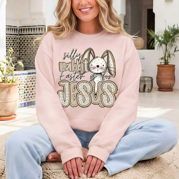 Silly Rabbit Easter Is For Jesus DTF Heat Transfer, image of a woman wearing a pink sweatshirt with a cute bunny and festive text design for Easter.