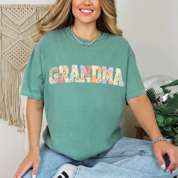Faux Fabric Patchwork Grandma DTF Heat Transfer, colorfully designed patchwork lettering spelling 'GRANDMA' on a green T-shirt.