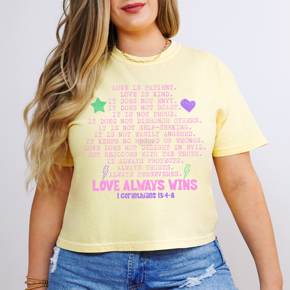 Love Always Wins DTF Heat Transfer, colorful text and symbols on a yellow T-shirt.