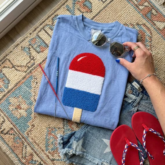 Patriotic Popsicle Fluffy Patch, fuzzy red, white, and blue Popsicle patch on a blue t-shirt with red flip-flops, denim shorts, sunglasses, and craft tools.