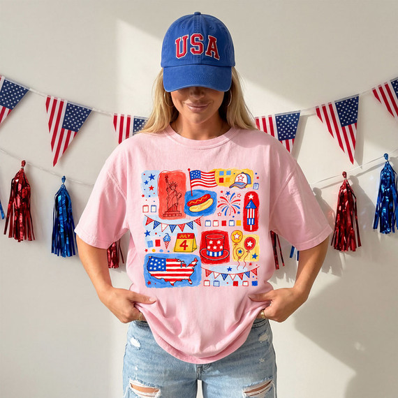 USA Icon Doodle DTF Heat Transfer, patriotic American-themed illustrations on a pink t-shirt worn by a woman, featuring the Statue of Liberty, American flags, fireworks, and July 4th symbols.