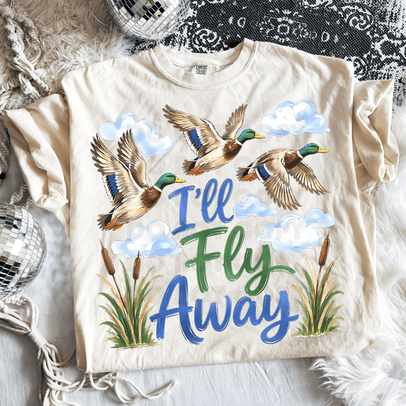 I'll Fly Away Mallard DTF Heat Transfer, colorful heat transfer design featuring flying mallard ducks, clouds, and cattails with the text 'I'll Fly Away' on a white T-shirt.