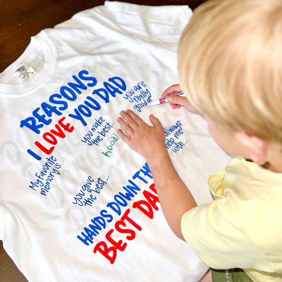Reasons I Love Dad DTF Heat Transfer, close-up of a person writing on a white T-shirt with blue and red text using a marker