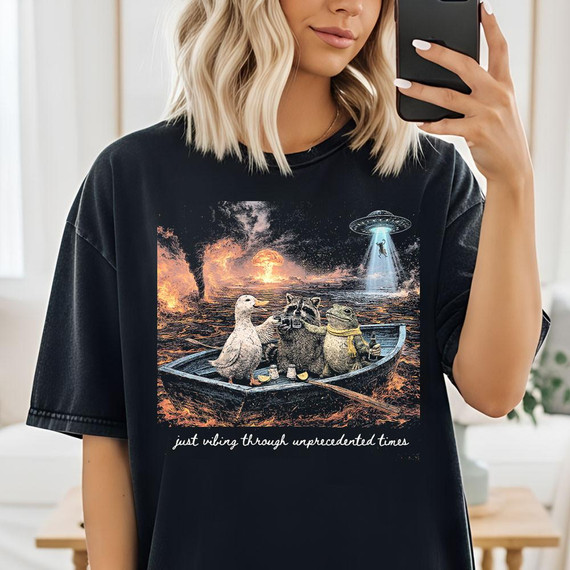 Just Vibing Through Unprecedented Times DTF Heat Transfer, humorous graphic of animals in a boat with UFO and apocalyptic background.