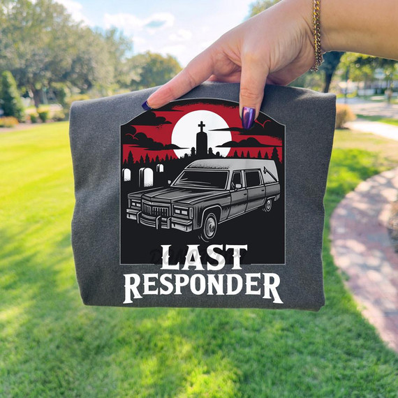 Last Responder Cemetery DTF Heat Transfer, a black and white graphic design of a hearse with a cemetery background and a cross at sunset, printed on a gray fabric.