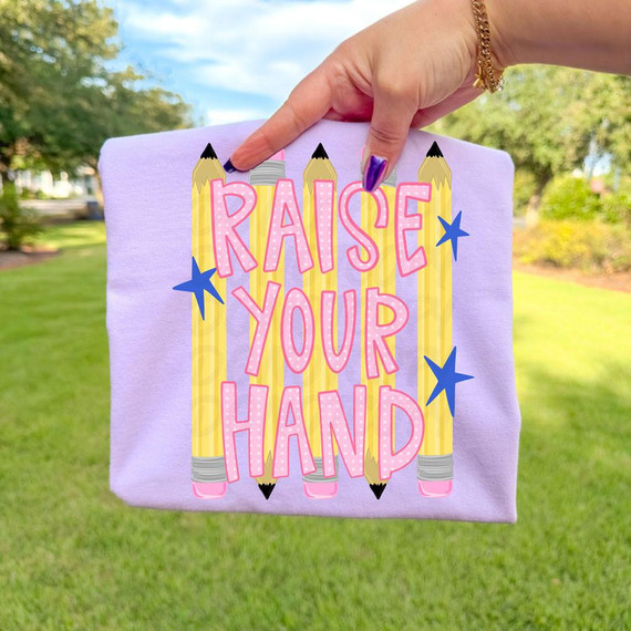 Raise Your Hand DTF Heat Transfer, colorful design with pencils and stars on purple fabric, applied to a clothing item or fabric.