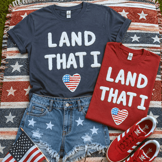 Land That I Love Fluffy Patch, patriotic T-shirts with American flag heart designs, denim shorts with star prints, and red Adidas sneakers on a star-spangled blanket.