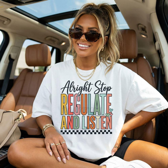 Alright Stop Regulate And Listen BLACK DTF Heat Transfer on a woman's white t-shirt, in a car interior with tan leather seats, sunglasses, and jewelry.