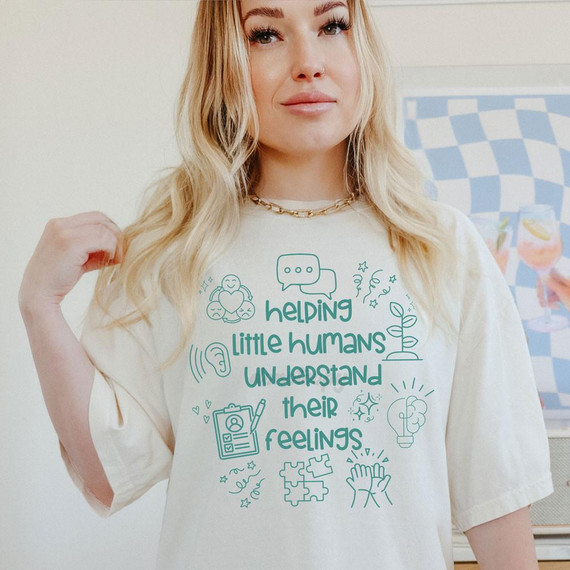Helping Little Humans Understand Their Feelings GREEN DTF Heat Transfer, a white T-shirt with teal-colored illustrations and text about children's emotional awareness.