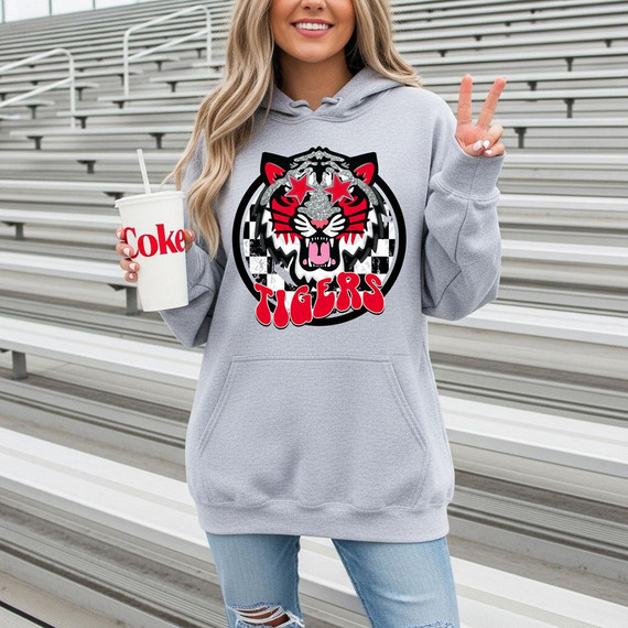Red Tigers Mascot DTF Heat Transfer, a bold and colorful tiger mascot design on a light gray hoodie with a checkerboard background, featuring the word 'TIGERS' in red letters.