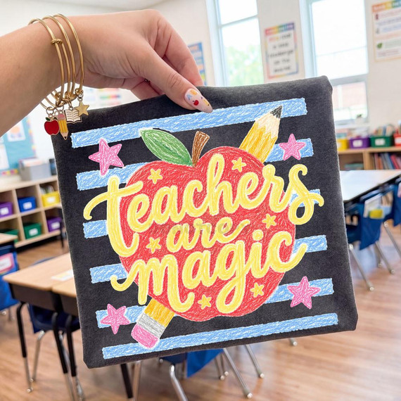 Teachers Are Magic DTF Heat Transfer, colorful embroidered design on a black fabric square with educational-themed artwork in a classroom setting.