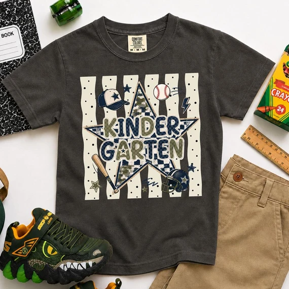 Sports Star Grade Level DTF Heat Transfer, athletic-themed design on a dark gray kids' t-shirt with baseball, football, and star graphics.