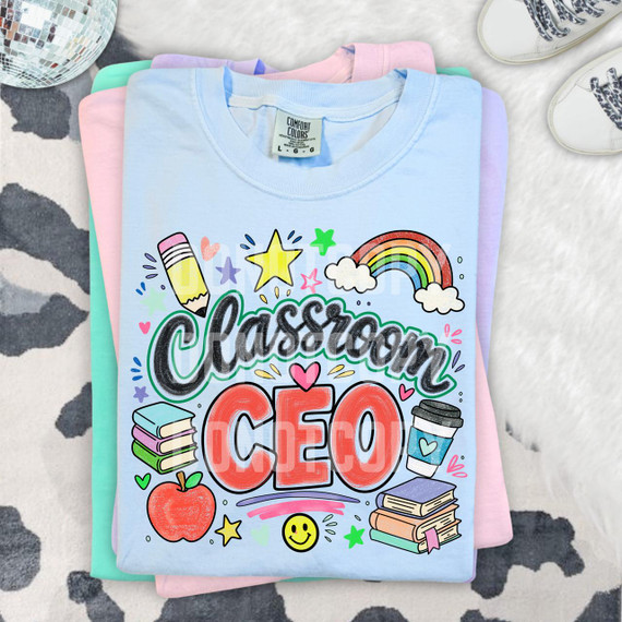 Classroom CEO DTF Heat Transfer, colorful classroom-themed design on a light blue t-shirt featuring books, a coffee cup, rainbow, heart, star, apple, and smiley face illustrations.