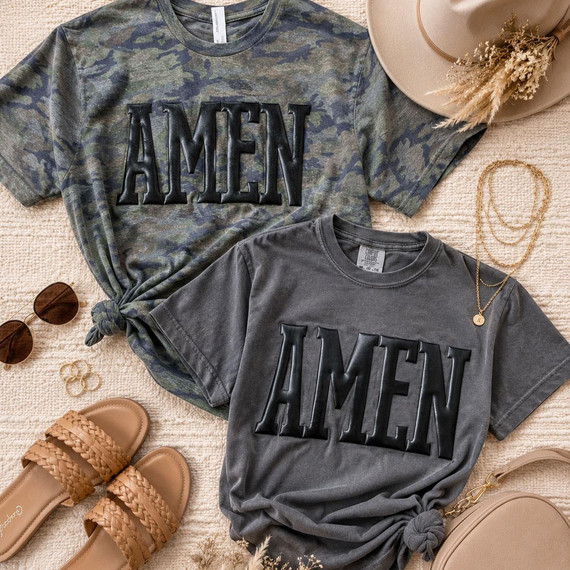 Amen Black Metallic Puff Heat Transfer, two casual t-shirts with black metallic puff lettering, surrounded by fashion accessories on beige textured background.