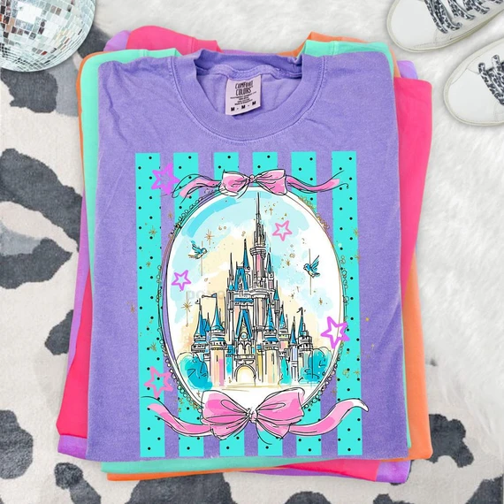 Coquette Fairytale Castle DTF Heat Transfer, colorful castle design with pastel pink bows, stars, and birds on a purple t-shirt.