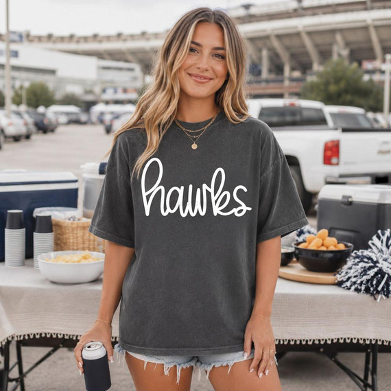 Hawks WHITE DTF Heat Transfer, close-up of a woman wearing a black t-shirt with white 'hawks' text for custom sports team apparel.
