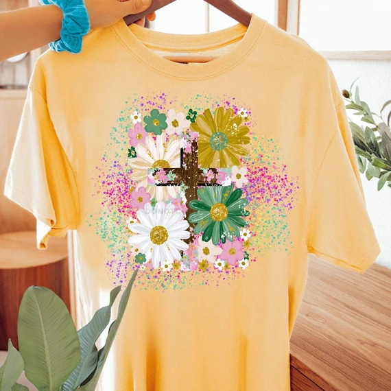 Floral Cross Paint Splatter DTF Heat Transfer, colorful floral and splatter design on a yellow T-shirt.
