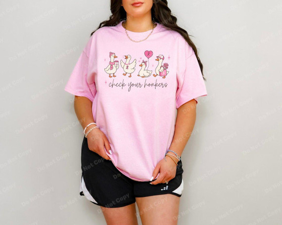 Check Your Honkers Goose DTF Heat Transfer, a humorous pink T-shirt featuring cartoon geese and text, worn by a woman.