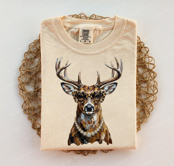 Glam Whitetail Deer DTF Heat Transfer, stylish deer wearing sunglasses and a pearl necklace on a beige t-shirt.