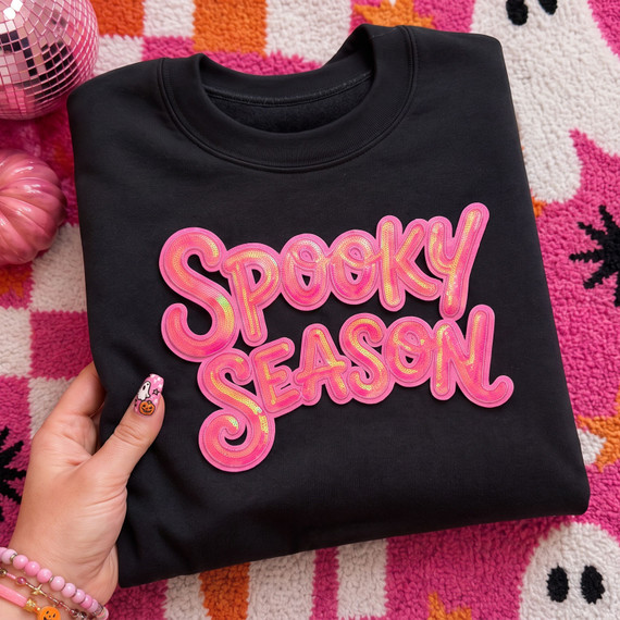 Pink Spooky Season Halloween apparel patch with iridescent sequin lettering displayed on a black sweatshirt