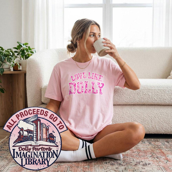 Love Like Dolly DTF Transfer, Pink Floral Varsity Country Design on a pink T-shirt worn by a woman sitting on the floor drinking coffee.